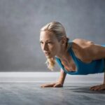 Hashtags Fitness Motivation Selfie of woman at gym using #FitnessMotivation hashtags to share workout inspiration on social media